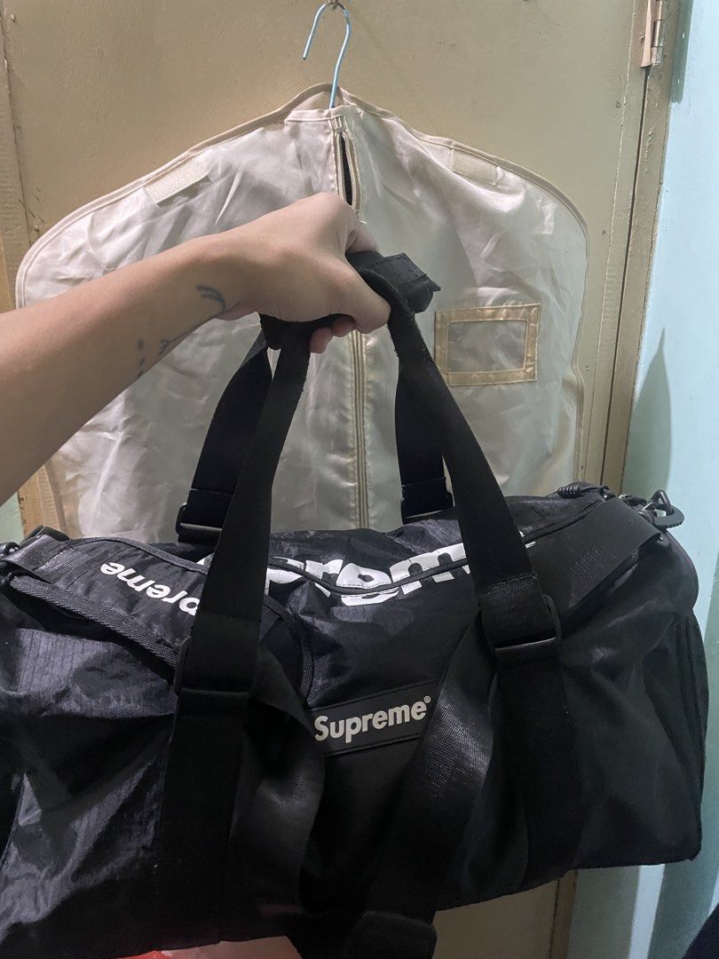 Supreme Duffle Bag Black White Logo (Category: Sling Bags) located in Baguio. Submitted by claw_set (Listing ID 1462590783, Image 3). Description: - Stylish black duffle bag with iconic white Supreme logo. - Versatile carrying options: comfortable shoulder strap and sturdy top handles. - Convenient interior zippered pocket for secure storage. - Ideal for your next travel adventure or gym sessions. .