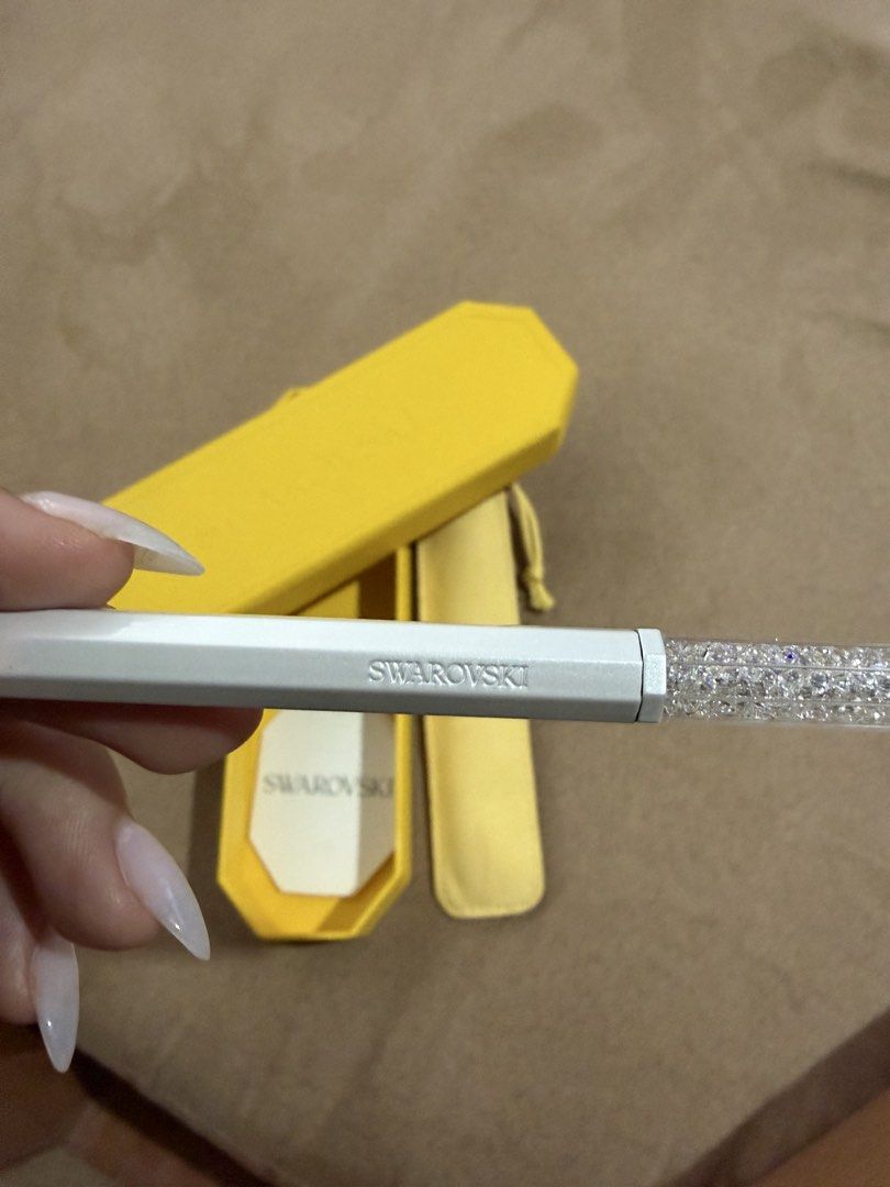 Swarovski Crystalline ballpoint pen (Category: Stationery & School Supplies) located in Manila. Submitted by yesapot (Listing ID 1462535724, Image 2). Description: - Authentic Swarovski pen - White barrel with sparkling crystal-filled top - Comes with original yellow case - Includes yellow pouch - Care instructions included - Features Swarovski logo on barrel - Ideal for gifting or personal use.