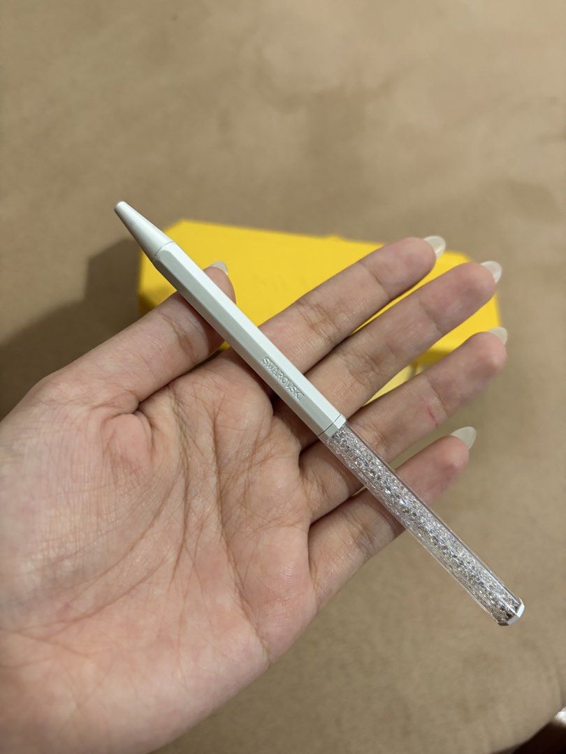 Swarovski Crystalline ballpoint pen (Category: Stationery & School Supplies) located in Manila. Submitted by yesapot (Listing ID 1462535724, Image 3). Description: - Authentic Swarovski pen - White barrel with sparkling crystal-filled top - Comes with original yellow case - Includes yellow pouch - Care instructions included - Features Swarovski logo on barrel - Ideal for gifting or personal use.