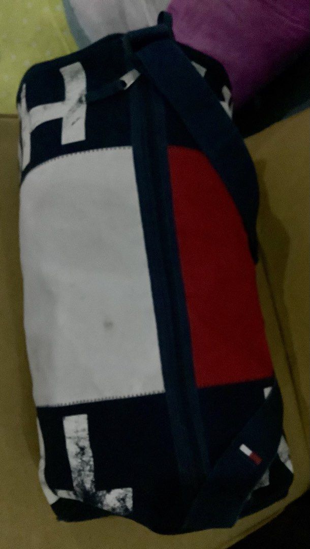 Tommy Hilfiger Red Blue White Duffle Bag (Category: Sling Bags) located in Quezon City. Submitted by heybailey (Listing ID 1462502321, Image 2). Description: - Classic Tommy Hilfiger duffel bag - Iconic red, white, and blue color block design - Navy blue strap and handles - Ideal for gym sessions or weekend getaways - Spacious interior - Shows some signs of wear (please check photos for details).