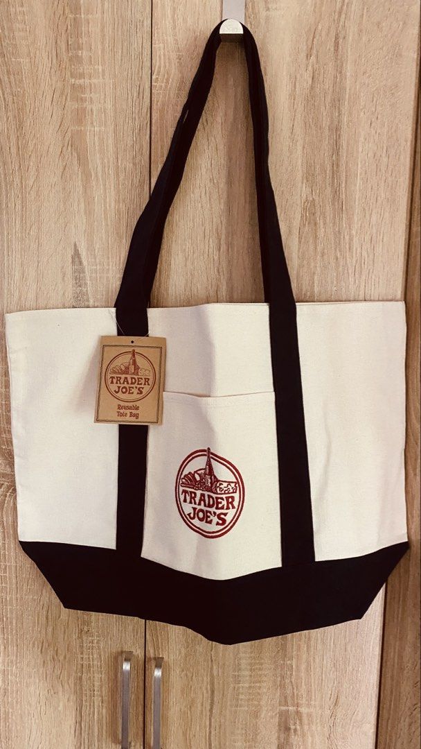 Trader Joe's Reusable Canvas Tote Bag (Category: Tote Bags) located in Quezon City. Submitted by starmax79 (Listing ID 1462508130, Image 1). Description: - Trader Joe's reusable tote bag - White canvas with black trim and handles - Features a front pocket with the Trader Joe's logo - Comes with original tag - Ideal for groceries or everyday use.