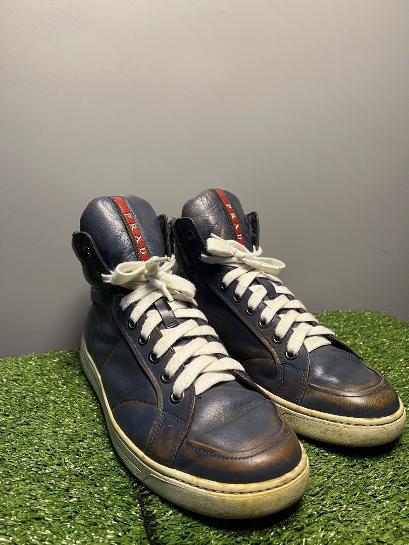 VINTAGE PRADA - DISTRESSED LEATHER HIGH TOP SNEAKERS (Category: Sneakers & Footwear) located in Bacolod City. Submitted by timelessbyjosh (Listing ID 1461969919, Image 2). Description: BEST FOR AVANT GARDE & STREETWEAR OUTFITS SIZE : 7 ACTUAL COLOR : COLOR RATE : 9 OUT OF 10 CONDITION : WELL USED MATERIAL : LIGHT NAVY BLUE MADE IN : VIETNAM FLAWS : YELLOWING ON THE SOLE, DISTRESSED LEATHER ( ADDS A CHARACTER ) , SHOELACE NEED CLEANING & MINIMAL S