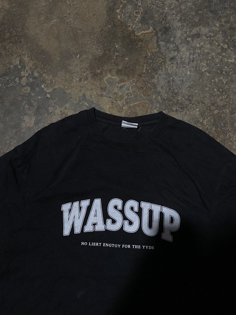 WASSUP Graphic T-Shirt (Category: Tshirts & Polo Shirts ) located in Munoz. Submitted by bb_jimbo0 (Listing ID 1462626574, Image 2). Description: - Black graphic t-shirt - Features 'WASSUP' text - Includes smaller text: 'NO LIERT ENGTOY FOR THE YYDS' - Simple and casual design - Ideal for everyday wear.