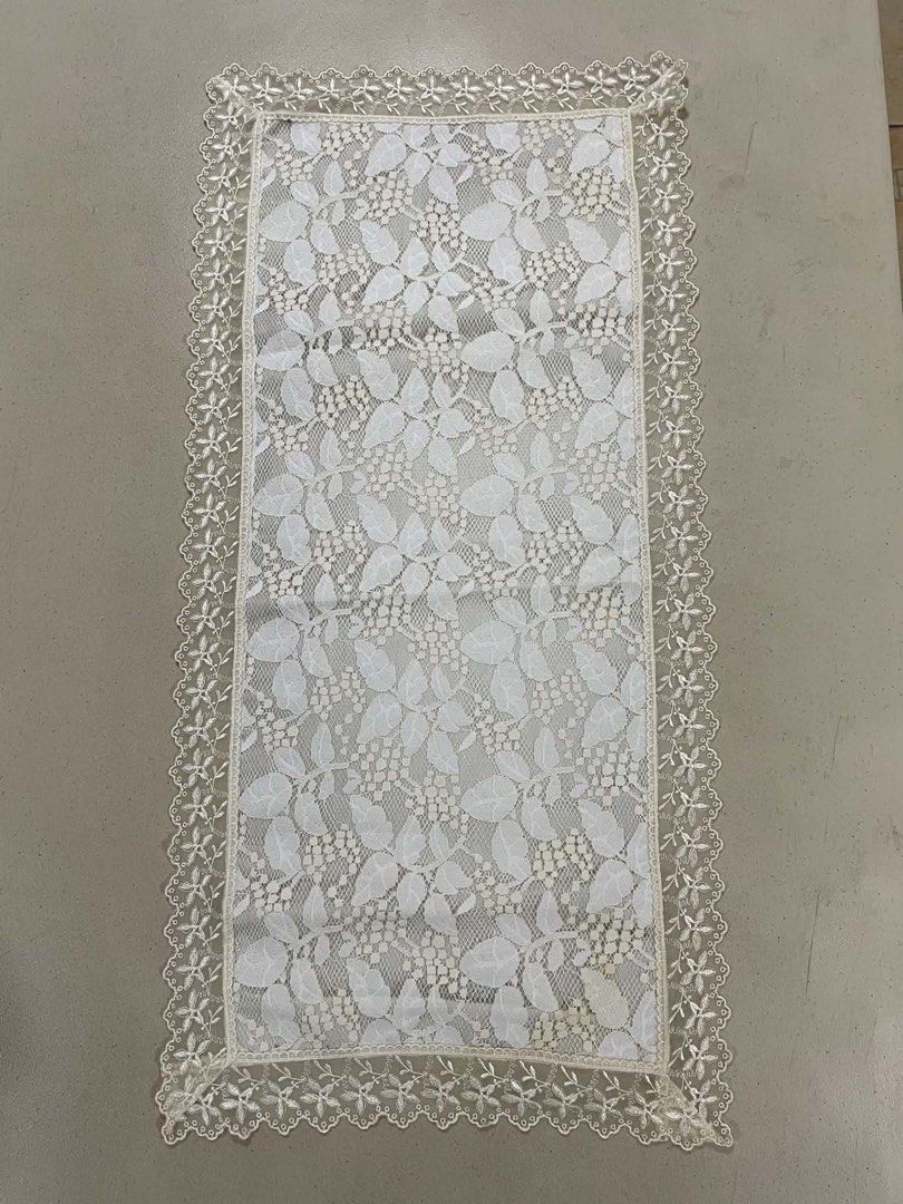 White Lace Table Runner with Floral Pattern (Category: Table Linen & Textiles) located in Quezon City. Submitted by meggoquingco (Listing ID 1462514372, Image 2). Description: - Beautiful white lace table runner - Features a lovely floral design - Delicate lace trim along the edges - Adds a decorative touch to dining tables or sideboards - Fabric has a subtle sheen.