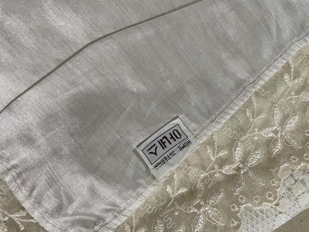 White Lace Table Runner with Floral Pattern (Category: Table Linen & Textiles) located in Quezon City. Submitted by meggoquingco (Listing ID 1462514372, Image 3). Description: - Beautiful white lace table runner - Features a lovely floral design - Delicate lace trim along the edges - Adds a decorative touch to dining tables or sideboards - Fabric has a subtle sheen.