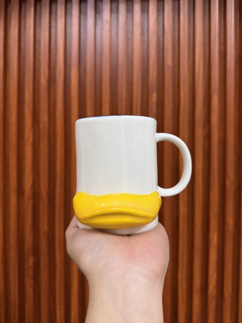 White Mug with Yellow Duck Design (Category: Coffee & Tea Tableware) located in Trece Martires City. Submitted by pololololeng (Listing ID 1462492345, Image 1). Description: > Adorable white mug with a unique yellow duck bill design at the bottom. > Ideal for your daily coffee or tea rituals. Can be a wonderful and thoughtful gift. .