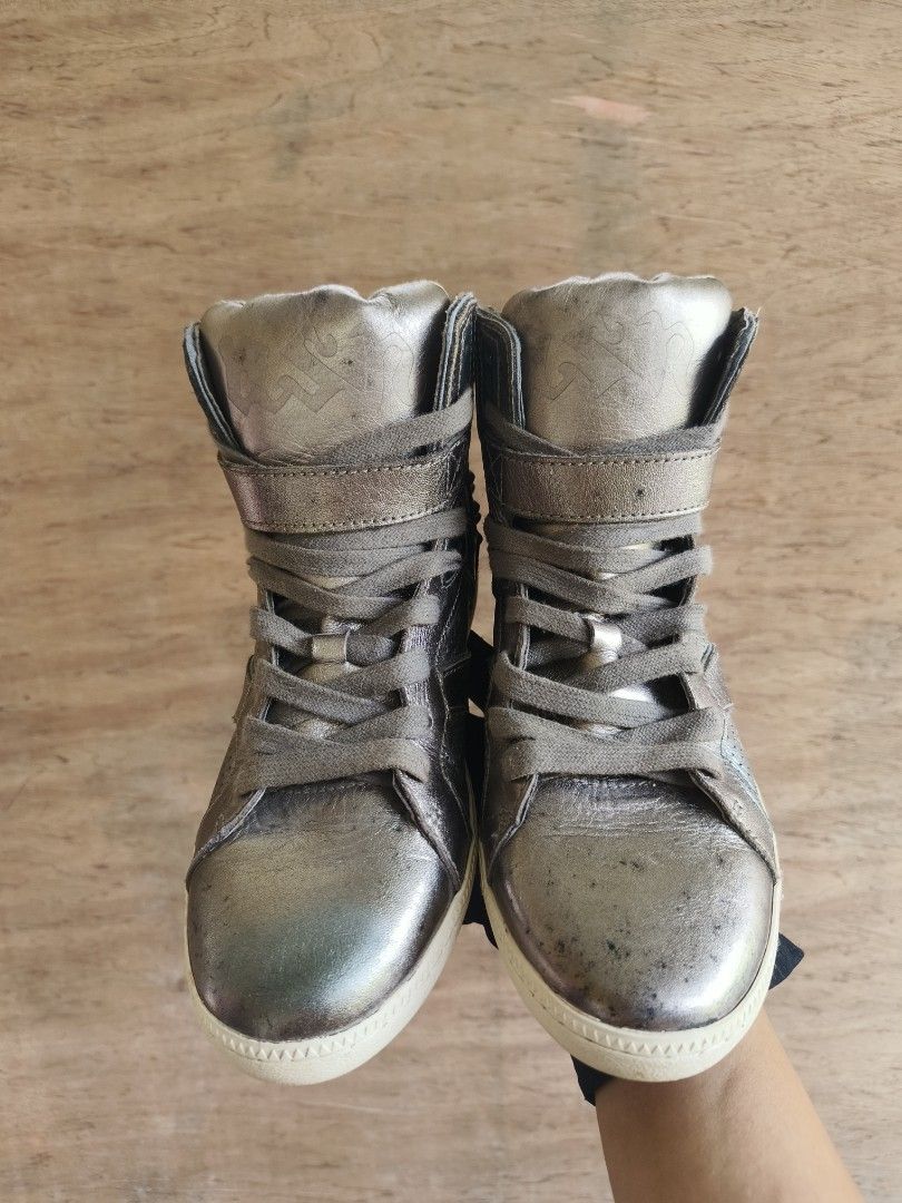 Y2k ASH Gold Studded High-Top Sneakers with Strap (Category: Sneakers) located in Davao. Submitted by vndrgd (Listing ID 1462450962, Image 2). Description: - Eye-catching gold high-top sneakers - Features a strap closure for a secure fit - Bold stud embellishments on the back - Stylish perforated details on the sides - Classic lace-up front closure - Unique design for a statement-making look.