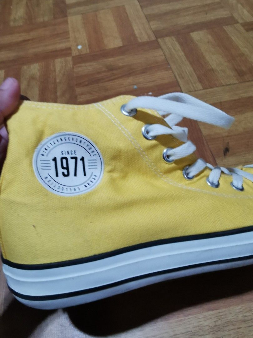 Yellow High Cut Sneakers "Since 1971" Collection (Category: Sneakers) located in Caloocan City. Submitted by mjmnacino204562 (Listing ID 1462559612, Image 2). Description: - Yellow high-top sneakers - "Since 1971" graphic on the side - Lace-up closure - White sole with black trim - Size 40 (25cm) - Ideal for casual wear - Minor marks on toe area (please check photos for details) RFS: No longer needed USED ONCE.