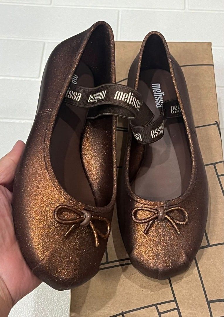 100% ORIGINAL MELISSA (Category: Flats & Sandals) located in Manila. Submitted by mydytrends (Listing ID 1462856570, Image 2). Description: - 100% Original Melissa Sophie flats - Color: Bronze with subtle shimmer - Size: 8 - Material: Signature Melissa jelly - Features a cute bow detail and elastic strap for secure fit.