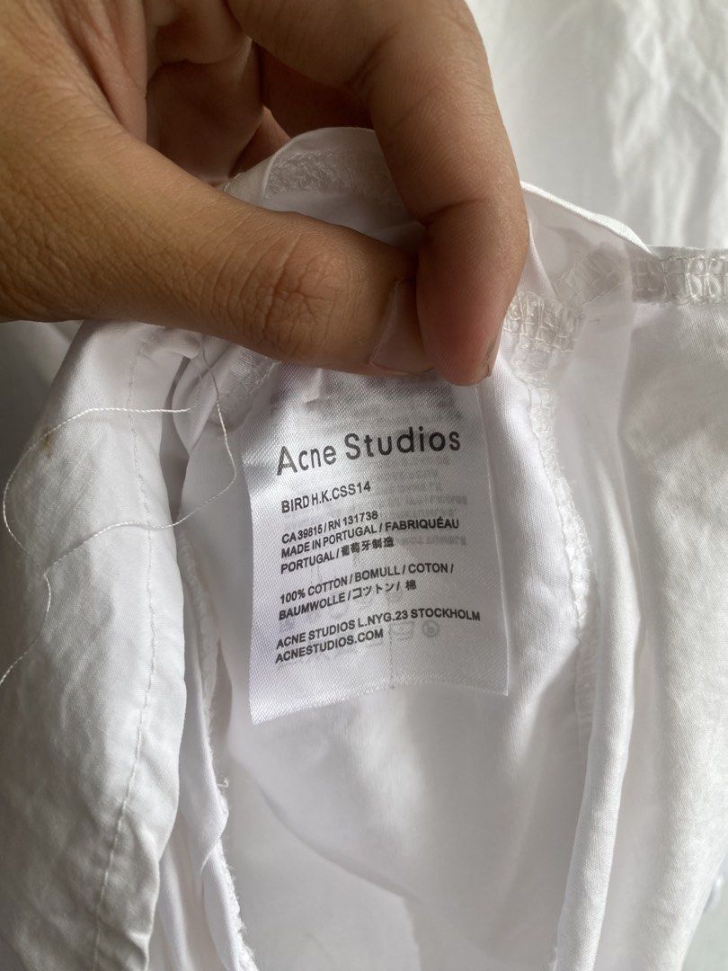 Acne Studios White Cotton Button-Up Shirt (Category: Tshirts & Polo Shirts ) located in Manila. Submitted by anthony1723 (Listing ID 1462716447, Image 3). Description: - Classic white button-up shirt from Acne Studios - Made from 100% premium cotton - Features a relaxed fit and stylish curved hem - Perfect for versatile styling – wear it alone or layer it up - A must-have staple for any wardrobe.