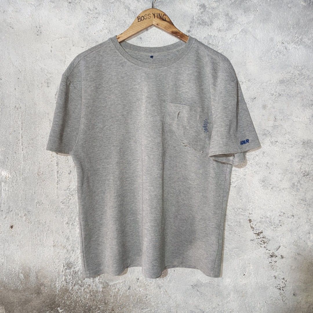 ADER Error | Men's Grey T-Shirt Pocket Tee (Category: Tshirts & Polo Shirts ) located in Naga. Submitted by bossyingthrifts (Listing ID 1462772588, Image 2). Description: ADER Error | Men's Grey T-Shirt Pocket Tee - ADER Error Grey T-Shirt - Features a chest pocket with distressed detailing - Small ADER logo embroidered on the sleeve - Distinctive small blue tag near the collar - Ideal for casual and everyday styling Size: A1 on tag (can fit Larg