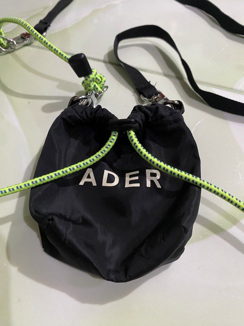 ADER Error Black Drawstring Pouch Bag with Neon Cord (Category: Purses & Pouches) located in Pozorrubio. Submitted by izaykite2g (Listing ID 1462861359, Image 3). Description: - Black drawstring pouch bag - Features ADER logo on the front - Includes a black strap - Neon green cord detail - Versatile: can be worn crossbody or as a shoulder bag - Small size, ideal for carrying essentials - Please check photos for detailed condition.