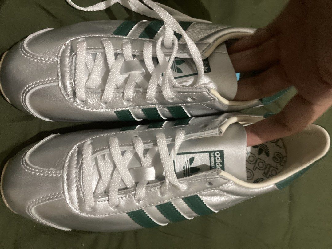 Adidas Silver Green Stripes Sneakers (Category: Sneakers) located in Tacloban City. Submitted by sid1999 (Listing ID 1462699801, Image 1). Description: - Silver Adidas sneakers - Features iconic green stripes - Classic lace-up closure - Made in Indonesia - Size: US 6 / UK 4.5 / FR 37.5 / JP 230 / CHN 230 (refer to label for full details) - Ideal for everyday casual wear.
