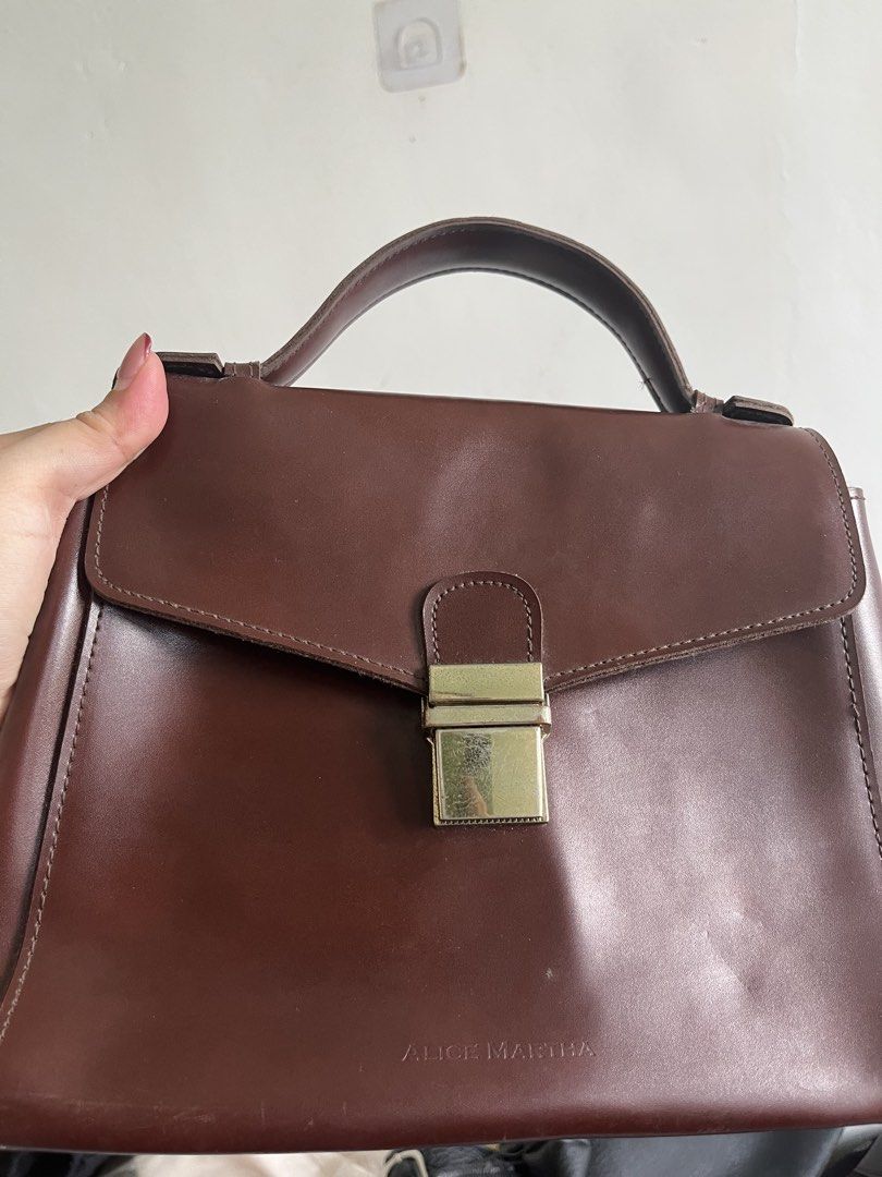 Alice Martha Brown Leather Top Handle Bag with Strap (Category: Cross-body Bags) located in Taguig. Submitted by swiftearth_250c75 (Listing ID 1462757612, Image 2). Description: - Brand: Alice Martha - Material: Genuine Leather - Color: Brown - Handle: Top handle - Strap: Detachable shoulder strap - Closure: Gold-tone clasp - Interior: Zippered pocket, small leather tag - Versatile: Ideal for daily use or special occasions.