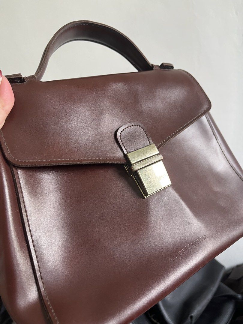 Alice Martha Brown Leather Top Handle Bag with Strap (Category: Cross-body Bags) located in Taguig. Submitted by swiftearth_250c75 (Listing ID 1462757612, Image 3). Description: - Brand: Alice Martha - Material: Genuine Leather - Color: Brown - Handle: Top handle - Strap: Detachable shoulder strap - Closure: Gold-tone clasp - Interior: Zippered pocket, small leather tag - Versatile: Ideal for daily use or special occasions.