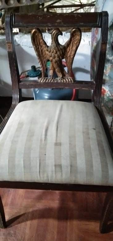 Antique Wooden Chair with Eagle Accent (Category: Chairs) located in Caloocan City. Submitted by jeicee858582831 (Listing ID 1462856955, Image 1). Description: - Unique wooden chair with ornate eagle carving on the backrest. - Features a comfortable seat with a striped fabric cushion. - Shows some signs of wear on the wood finish, adding character. - Perfect for adding a unique touch to your home decor. - Selling as is..