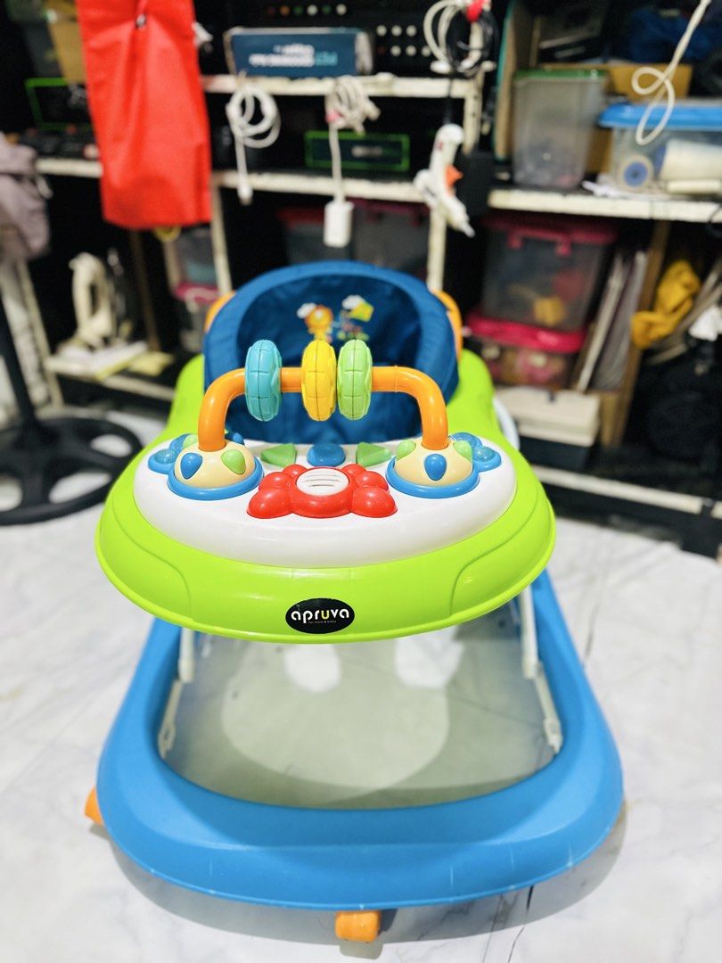 Apruva Baby Walker with Toys (Category: Infant Playtime) located in Manila. Submitted by allysa023025488 (Listing ID 1462820768, Image 1). Description: Aprica baby walker in green and blue. Has a toy bar with spinning rings and buttons. Seat is blue with a lion print. Some wear and tear on the metal legs, as shown in photos. Still functional for little ones learning to walk..