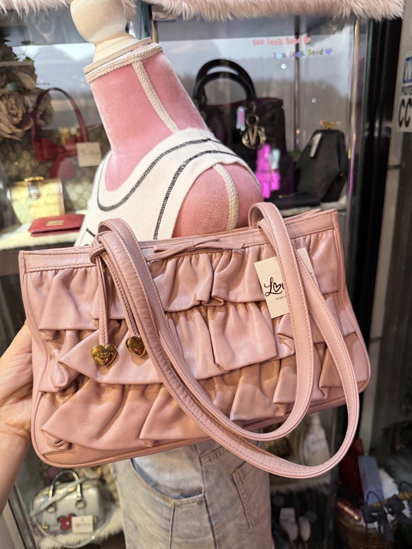 Authentic Lovcat Pink Ruffle Leather Shoulder Bag (Category: Shoulder Bags) located in Dumaguete. Submitted by lovebags.ph (Listing ID 1462827775, Image 3). Description: - Adorable pink shoulder bag from LoveBags. - Made of soft leather with charming ruffle details. - Features two small heart charms on the front tie. - Comfortable shoulder straps. - Ideal size for carrying your essentials. - Comes with the original tag..
