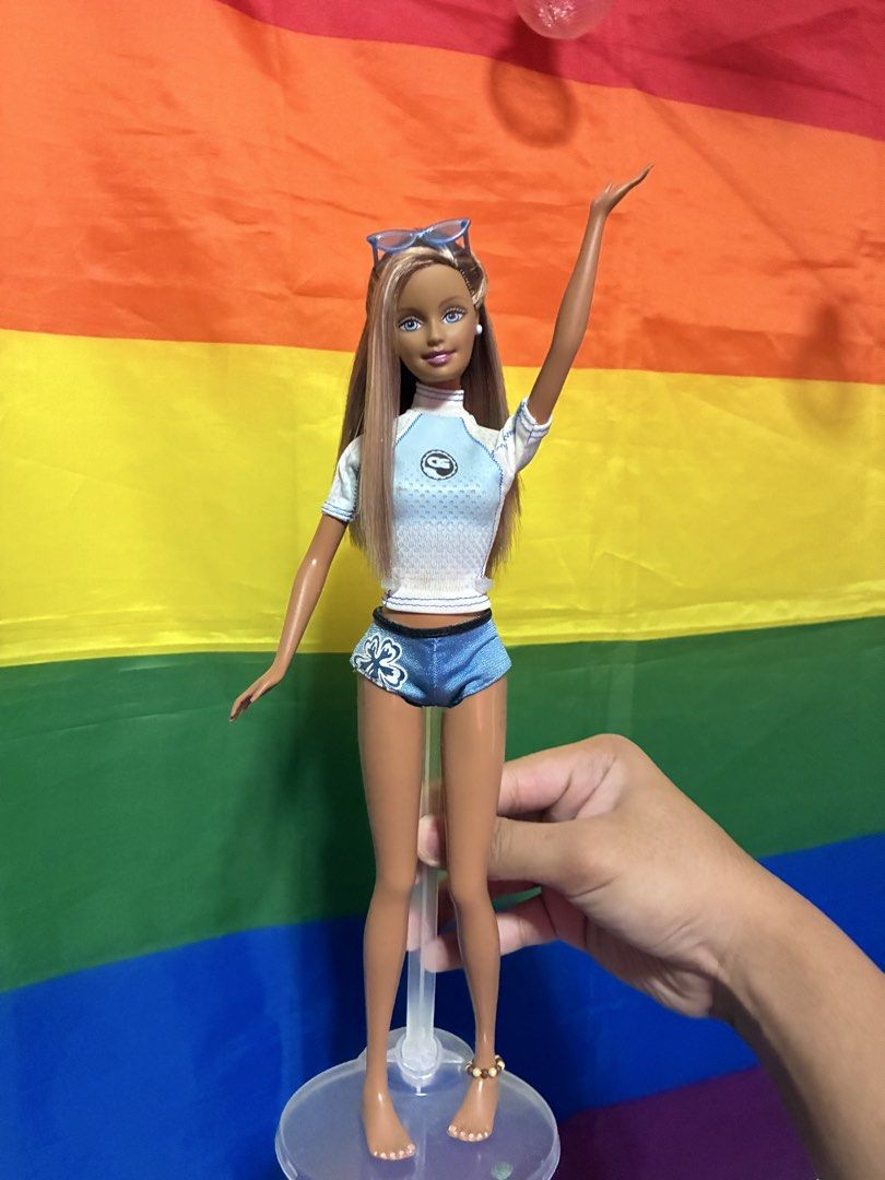 Cali Girl Barbie (Category: Kids Toys) located in Paranaque City. Submitted by roselyn.daria (Listing ID 1462811371, Image 1). Description: - cali girl barbie, complete accesories with original stand ( not in the photo) - i do have her original sunglasses and sunscreen -Barbie doll perfect for beach adventures! - Features a stylish blue and white floral rash guard and shorts. - Includes cool blue sunglasses perched on her head. - Adorned with a d