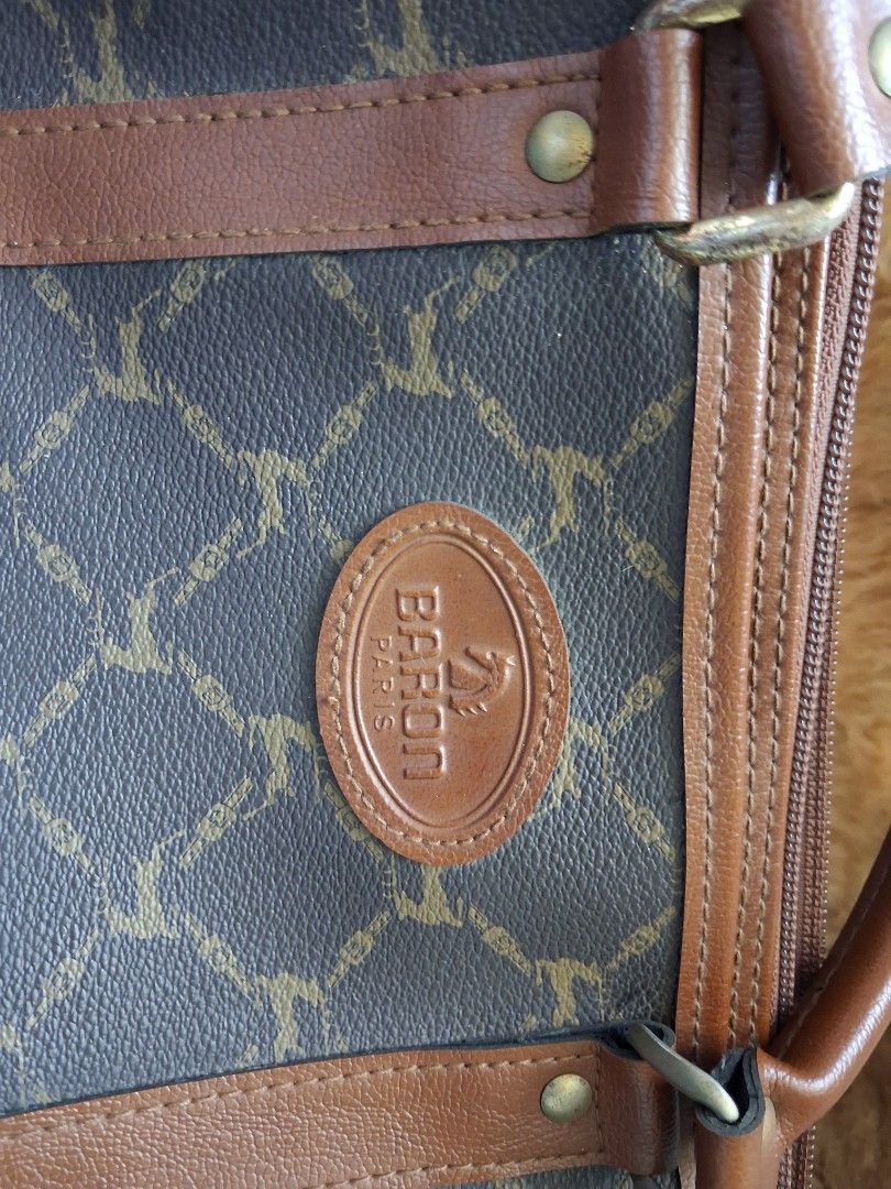 Baron Paris Bag （分類：手袋及銀包）位於 Hong Kong。 由 purecrystal_fe3b54 提交（商品編號 1462714734，圖片 2）。簡介： This is a bag from the brand Baron Paris, featuring a distinctive equestrian-themed monogram pattern.2c2875 Baronparis The main body uses a dark (charcoal/brownish) coated canvas or textured fabric printed with a repeating motif of stylized horses (or horse-like figures in profile/rearing poses) interlinked with chain or link elements in a lighter gold/beige