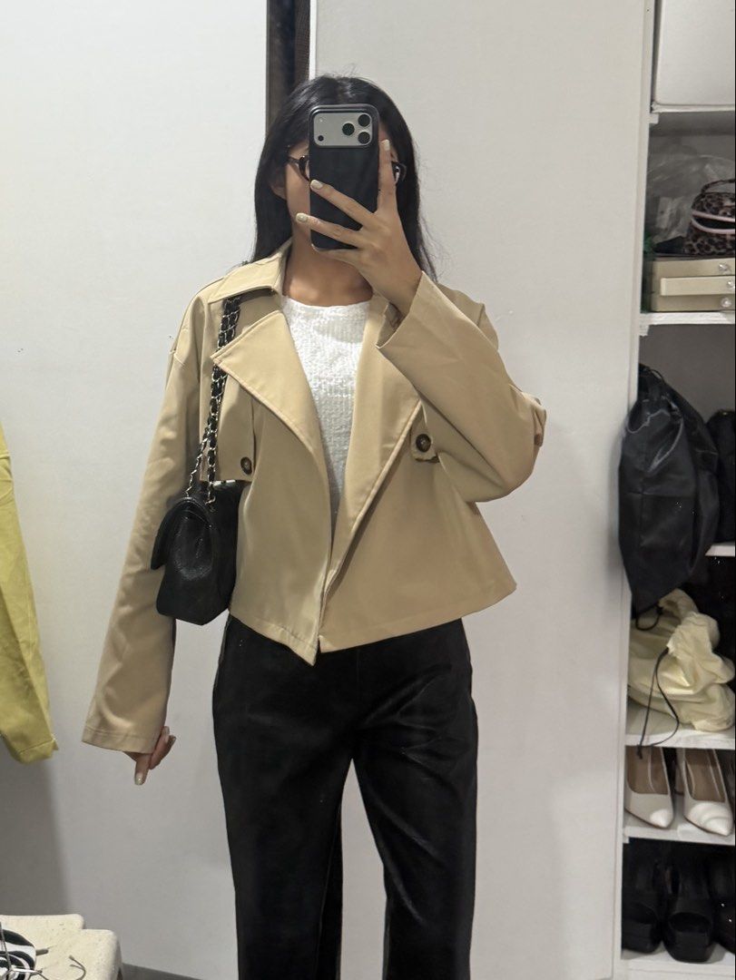 Beige Cropped Trench Jacket (Category: Coats, Jackets and Outerwear) located in Pasig City. Submitted by miss_abuelita (Listing ID 1462778062, Image 3). Description: - Cute beige cropped jacket - Mini trench coat inspired design - Two button details on the front - Ideal for layering over tops - Versatile for casual or slightly dressy outfits - Great for cooler weather.