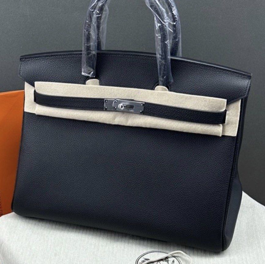 Birkin Togo 35 Palladium (Category: Luxury Bags & Wallets) located in Muntinlupa City. Submitted by decluttering.era.alabang (Listing ID 1462834168, Image 3). Description: - Classic black Hermes Birkin bag - Textured leather exterior - Silver hardware details - Top handles and flap closure - Comes with dust bag and orange Hermes box .