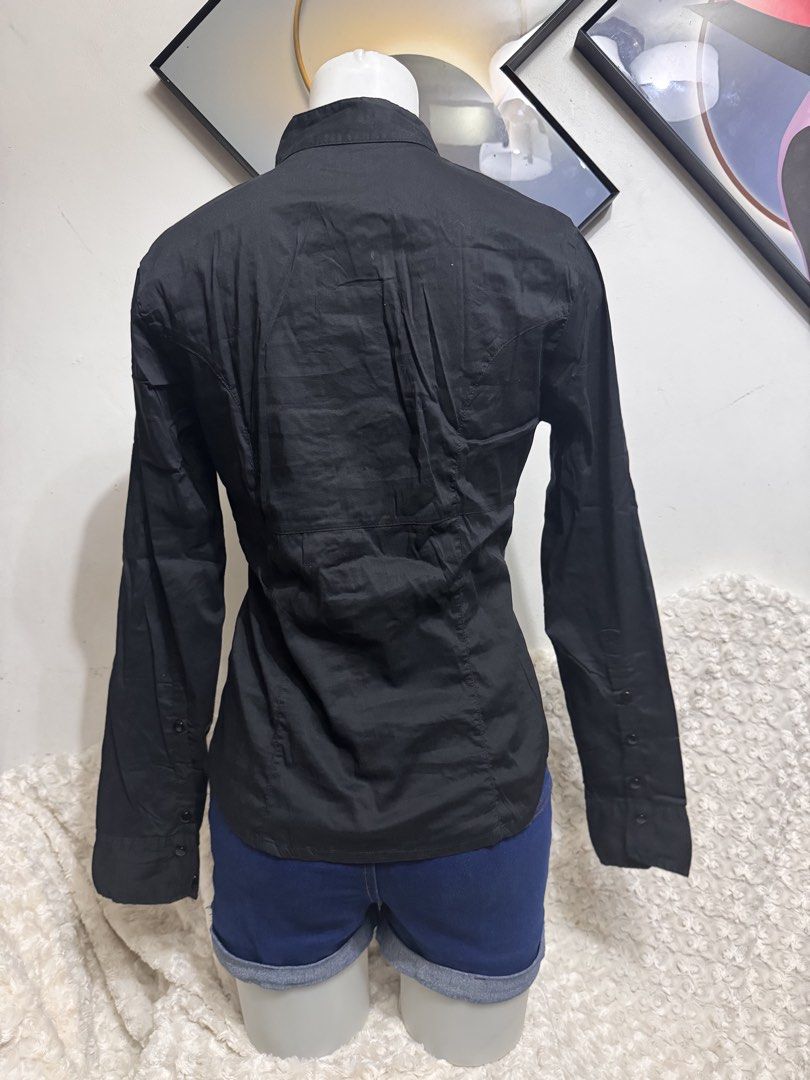 Black Long Sleeve Ruffle Front Button Up Shirt (Category: Blouses) located in Marikina City. Submitted by lorradel (Listing ID 1462729181, Image 3). Description: - Classic black long-sleeved shirt - Features a ruffled front detail - Button closure - Fitted silhouette - Versatile for dressing up or down - Easy to pair with skirts or trousers - MAY HAVE some washable stains (hindi maiiwasan) needs washing; had been stored - mannequin size 34-26-34 