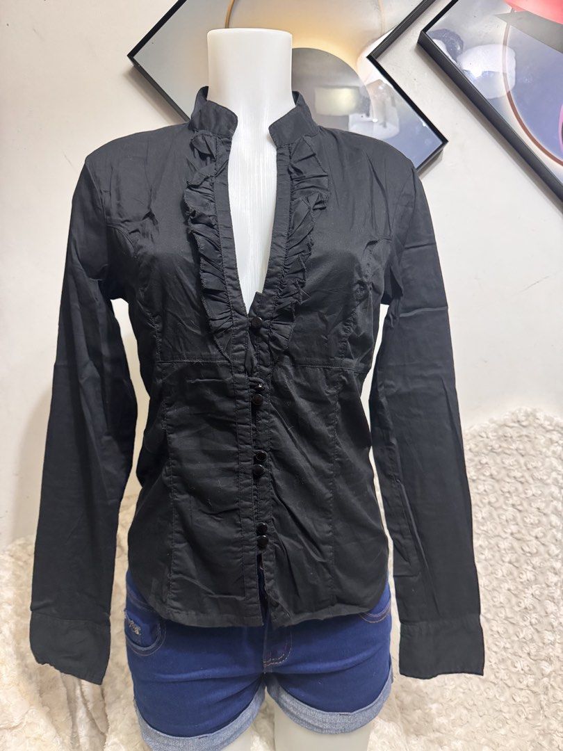 Black Long Sleeve Ruffle Front Button Up Shirt (Category: Blouses) located in Marikina City. Submitted by lorradel (Listing ID 1462729181, Image 1). Description: - Classic black long-sleeved shirt - Features a ruffled front detail - Button closure - Fitted silhouette - Versatile for dressing up or down - Easy to pair with skirts or trousers - MAY HAVE some washable stains (hindi maiiwasan) needs washing; had been stored - mannequin size 34-26-34 