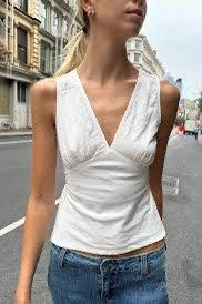 Brandy Melville White Rafaela Top (Category: Sleeveless) located in Quezon City. Submitted by im.a.shopaholic (Listing ID 1462682721, Image 1). Description: - Popular white Brandy Melville Edith white sleeveless v-nevk tank top - Cinched waist with tie detail at the back - Versatile: pairs well with jeans or skirts - Comfortable and breathable, perfect for casual day dates and night outs RFS: decluttering Location: Mandaluyong City .