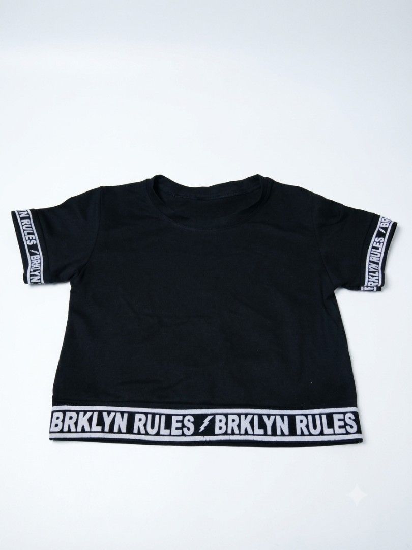 BRKLYN RULES Graphic Black Crop Top (Category: Shirts) located in Manila. Submitted by vbaykco (Listing ID 1462871096, Image 1). Description: BRKLYN RULES Black Statement Crop Top 🖤⚡ Level up your everyday streetwear fits with this black cropped tee. Features graphic "BRKLYN RULES" taped elastic trims along the sleeves and hem for an athletic, Y2K edge. Looks great paired with cargo pants, oversized blazers, or high-waisted denim!.