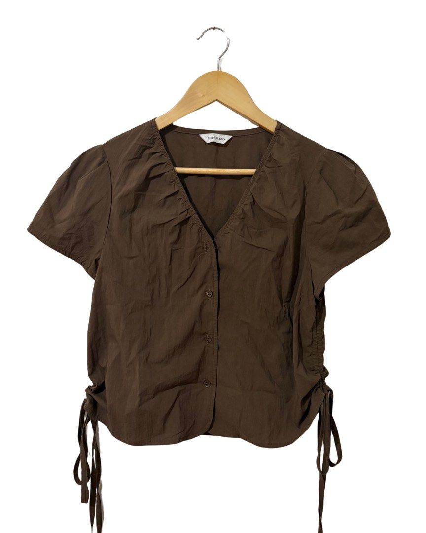 Brown Ruched Tie Side V-Neck Button Up Top (Category: Blouses) located in Subic. Submitted by ciesells (Listing ID 1462859846, Image 1). Description: bust: 35 - Top button missing - Button-up front - Ruched detailing on front and sides - Adjustable tie details on side hem - Lightweight fabric - Ideal for casual wear.