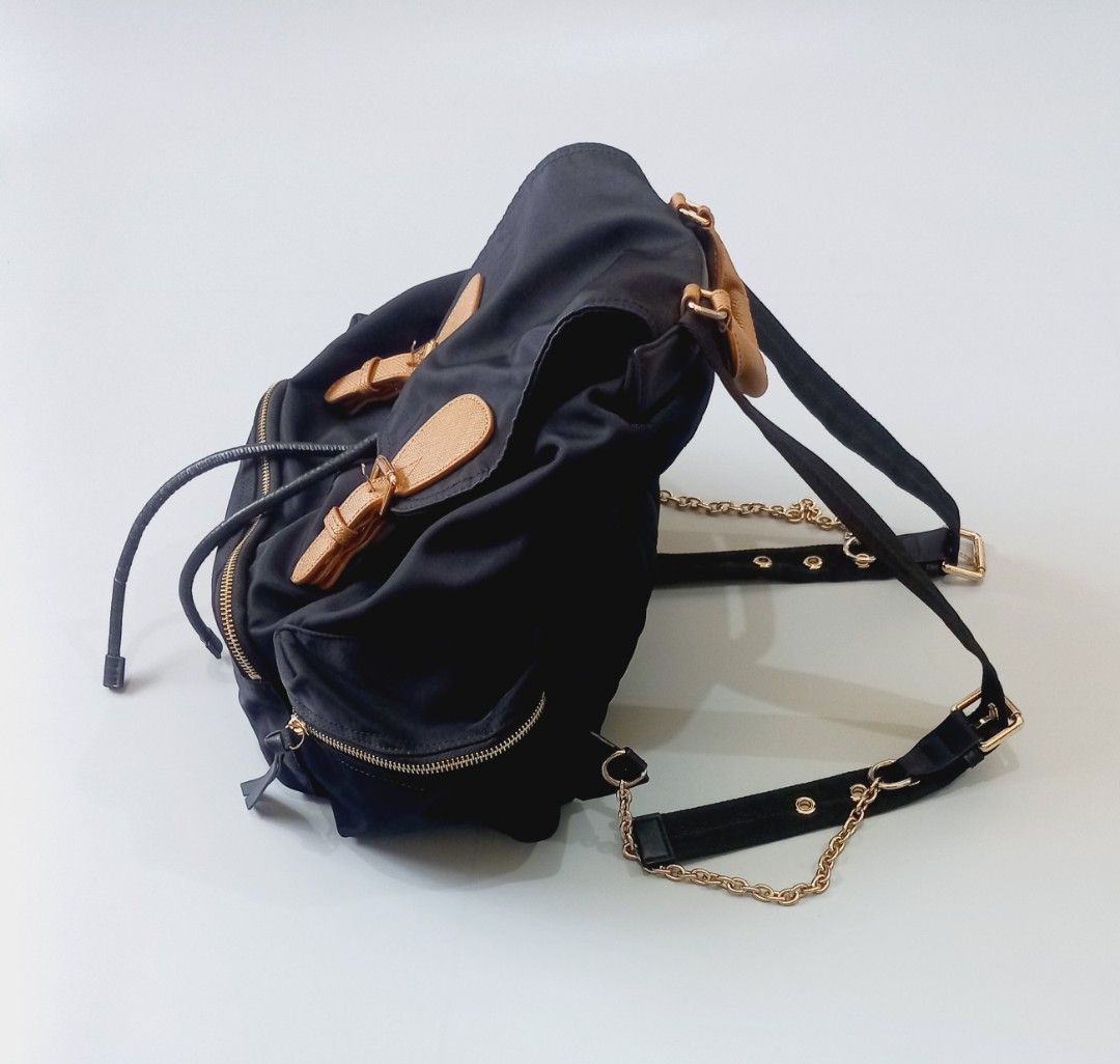 Burberry Black Nylon Leather Trim Backpack (Category: Luxury Bags & Wallets) located in Cebu City. Submitted by MrLiks_123 (Listing ID 1462851594, Image 2). Description: Authentic Burberry rucksack nylon backpack - Color: Black nylon with tan leather trim - Closure: Drawstring under flap with buckle - Hardware: Gold-tone with chain accents on straps - Features: Front zip pockets, quilted back panel - Ideal for: Everyday use casual formal event Ex