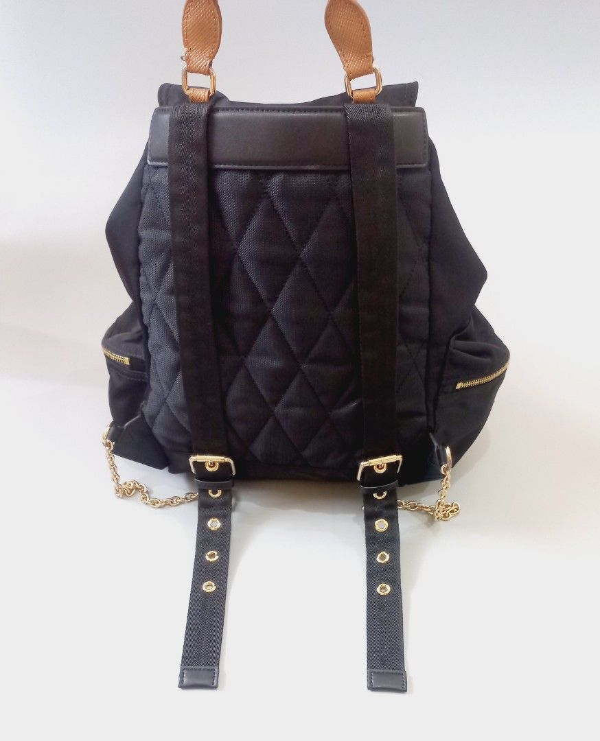 Burberry Black Nylon Leather Trim Backpack (Category: Luxury Bags & Wallets) located in Cebu City. Submitted by MrLiks_123 (Listing ID 1462851594, Image 3). Description: Authentic Burberry rucksack nylon backpack - Color: Black nylon with tan leather trim - Closure: Drawstring under flap with buckle - Hardware: Gold-tone with chain accents on straps - Features: Front zip pockets, quilted back panel - Ideal for: Everyday use casual formal event Ex