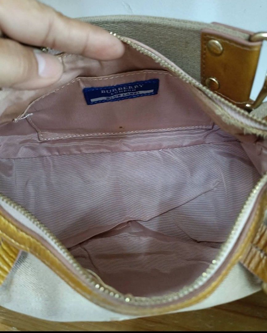 Burberry Blue Label Canvas Leather Shoulder Bag (Category: Luxury Bags & Wallets) located in Abucay. Submitted by chinithou (Listing ID 1462718563, Image 2). Description: - Authentic Burberry Blue Label shoulder bag - Beige canvas with tan leather accents - Gold hardware details - Interior: Pink lining with one small zip pocket - Condition: Clean interior - Ideal for everyday use.