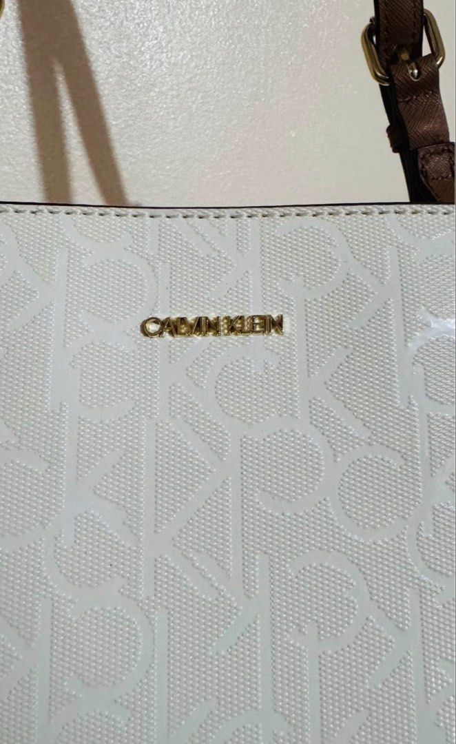 Calvin Klein White Monogram Floral Tote Bag (Category: Tote Bags) located in Paranaque City. Submitted by nikki_07 (Listing ID 1462728028, Image 3). Description: - Authentic white Calvin Klein tote bag - All-over CK monogram pattern - Charming floral print on front corners - Stylish brown handles - Elegant gold hardware - Spacious interior for all your essentials - Perfect for everyday use OK FOR SWAP TO YOUR BAG.