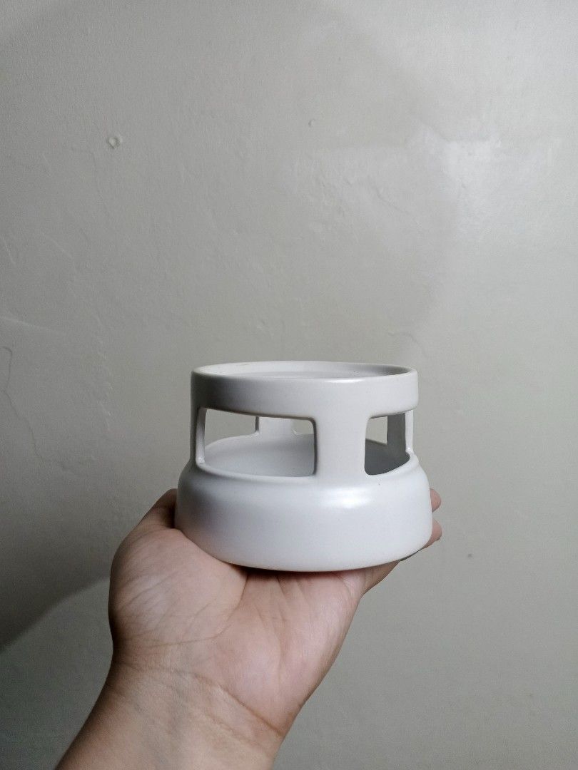 Candle Holder (Category: Other Home Decor) located in Quezon City. Submitted by pawenn (Listing ID 1462853474, Image 1). Description: - White candle holder - Minimalist and modern design - Features cut-out details for a unique look - Creates a warm and inviting atmosphere - Versatile for any home decor - Ideal for scented candles.