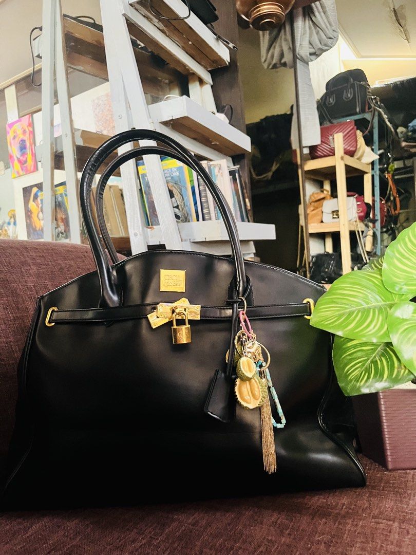 Cecille Mcbee (Category: Tote Bags) located in Quezon City. Submitted by retann (Listing ID 1462689918, Image 1). Description: - Classic black leather tote bag - Features a prominent gold lock - Includes decorative charms, including a unique durian charm - Sturdy and comfortable handles - Ample interior space for essentials - Versatile for daily use or special occasions.