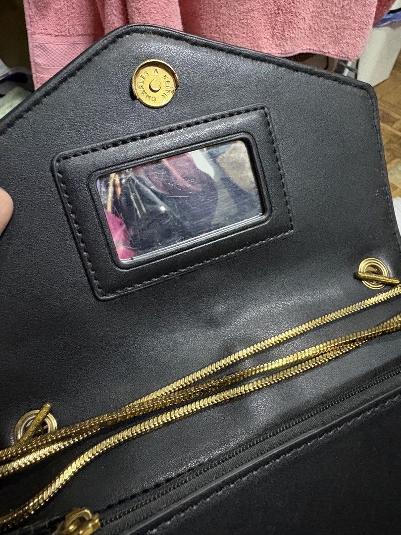 Charles & Keith Black Glitter Chain Sling Bag (Category: Cross-body Bags) located in Makati City. Submitted by cherriesforme (Listing ID 1462839144, Image 3). Description: - Stylish black sling bag - Eye-catching glitter detail on the front flap - Elegant gold chain strap - Decorative tassel accent - Convenient small mirror inside - Shows some signs of wear on the glitter (adds character!) - Ideal for nights out, parties, and special occasions.