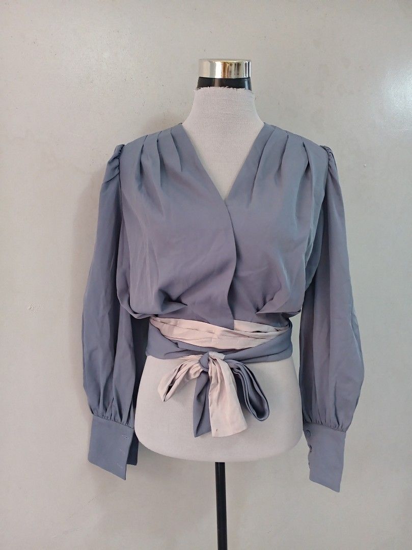 Classy Longsleeve blouse (Category: Blouses) located in Paranaque City. Submitted by janella11 (Listing ID 1462684659, Image 2). Description: - Wrap blouse - V-neckline - Gathered details at shoulders - Puff sleeves with buttoned cuffs - Includes a separate tie belt in a lighter shade - Cinch the waist for a stylish look.