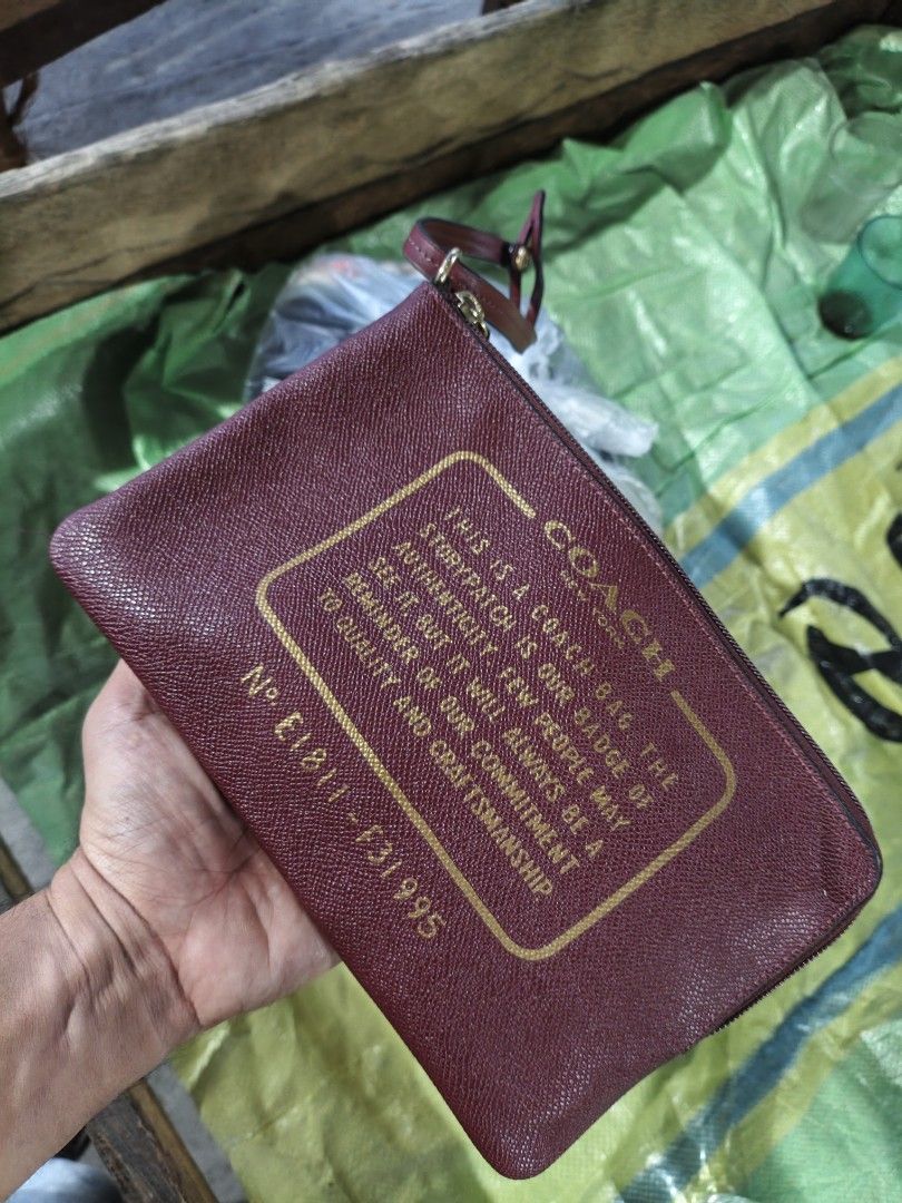 Coach Burgundy Leather Pouch with Gold Hardware (Category: Purses & Pouches) located in Maasim. Submitted by ukayganda25 (Listing ID 1462789429, Image 1). Description: - Authentic Coach pouch - Deep burgundy textured leather - Gold-tone hardware - Classic Coach creed on front - Interior Coach horse and carriage logo tag - Zipper closure - Small wrist strap attached.
