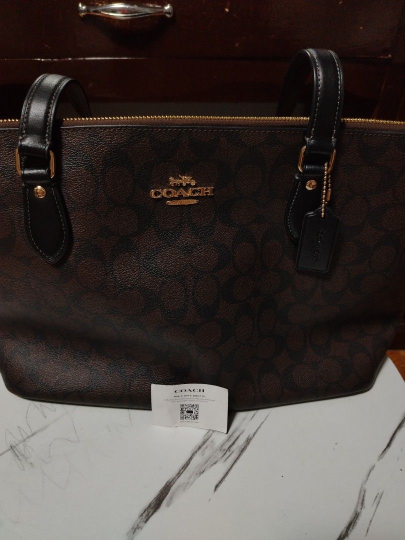 Coach Signature Brown Monogram Tote Bag (Category: Luxury Bags & Wallets) located in General Tinio. Submitted by crisantacruz (Listing ID 1462847553, Image 3). Description: - Authentic Coach tote bag - Signature brown monogram print - Elegant gold hardware details - Secure zip top closure - Includes original Coach hangtag - Interior Coach leather patch - Ideal everyday bag.