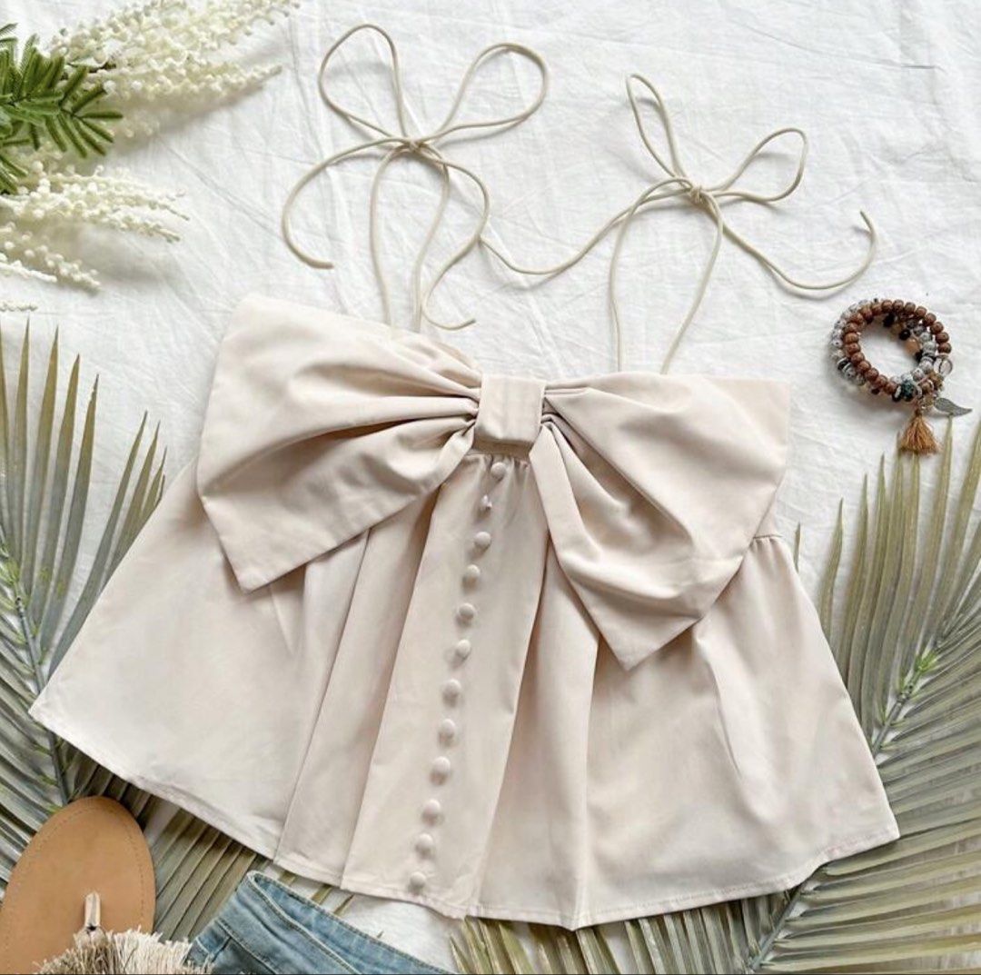 SHEIN ribbon top (khaki) (Category: Sleeveless) located in Quezon City. Submitted by jeydeegmr (Listing ID 1462706225, Image 1). Description: - Cute cream crop top - Features a big bow detail at the front - Adjustable tie straps - Smocked back for a comfy.