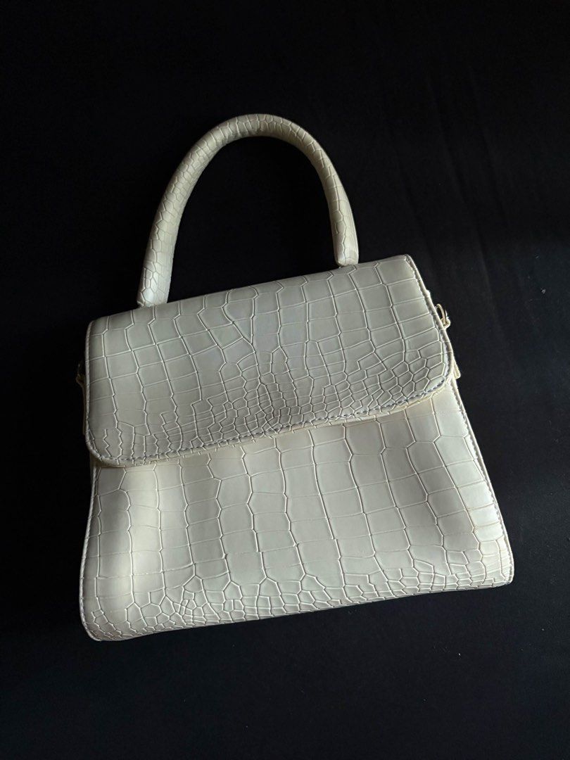 Cream Croc Embossed Top Handle Bag with Strap (Category: Luxury Bags & Wallets) located in Calamba. Submitted by leeadriannn796 (Listing ID 1462710368, Image 2). Description: - Chic cream-colored handbag - Luxurious croc-embossed texture - Versatile top handle and detachable shoulder strap - Secure flap closure with hidden magnetic snap - Practical interior with black fabric lining and a zippered pocket - Ideal for both daily wear and special eve