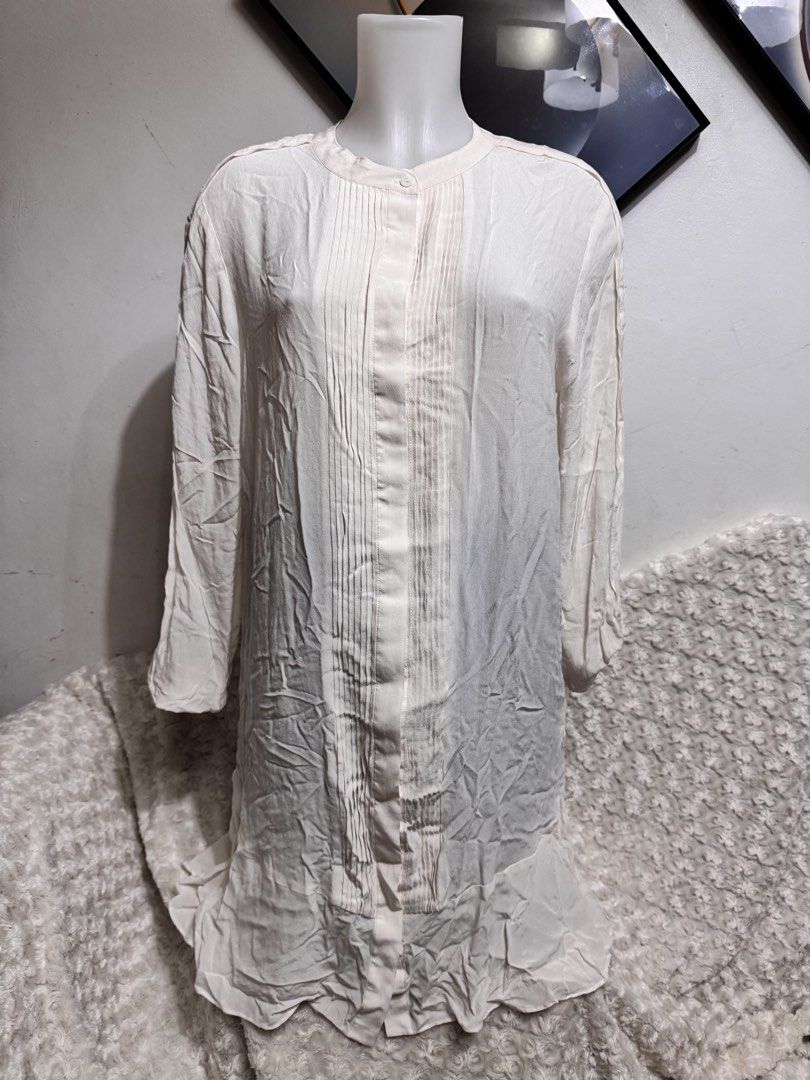 Cream Pleated Long Sleeve Button Up Blouse (Category: Dresses) located in Marikina City. Submitted by lorradel (Listing ID 1462718264, Image 1). Description: - XL on tag but fits L - Cream colored long sleeve blouse - Features subtle pleats down the front - Button up closure - Slight ruffle detail on the hem - Lightweight fabric, ideal for layering or wearing on its own - MAY HAVE some washable stains (hindi maiiwasan) needs washing; had been sto