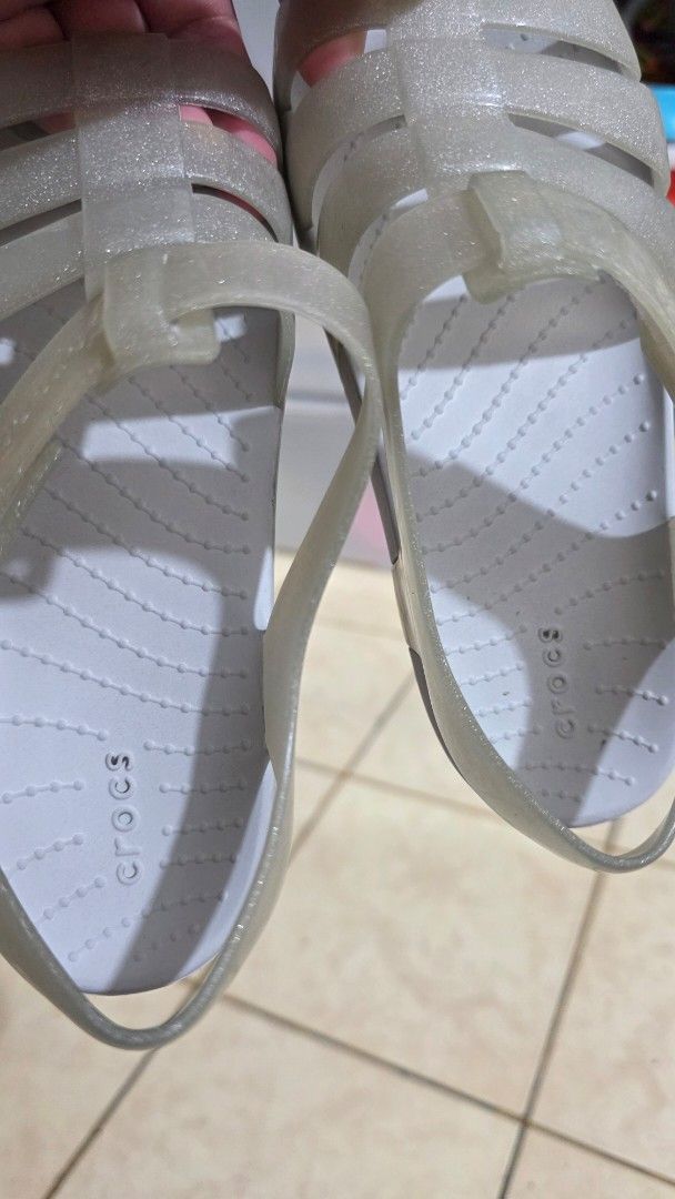 Crocs Glitter Jelly Sandals (Category: Babies & Kids Fashion) located in Manila. Submitted by joyceannelynne (Listing ID 1462825533, Image 3). Description: - Cute Crocs glitter jelly sandals - Translucent greyish color - Strappy fisherman style - Velcro strap closure for easy on/off - Ideal for beach or casual outings - Easy to clean material - Visible Crocs logo on strap.