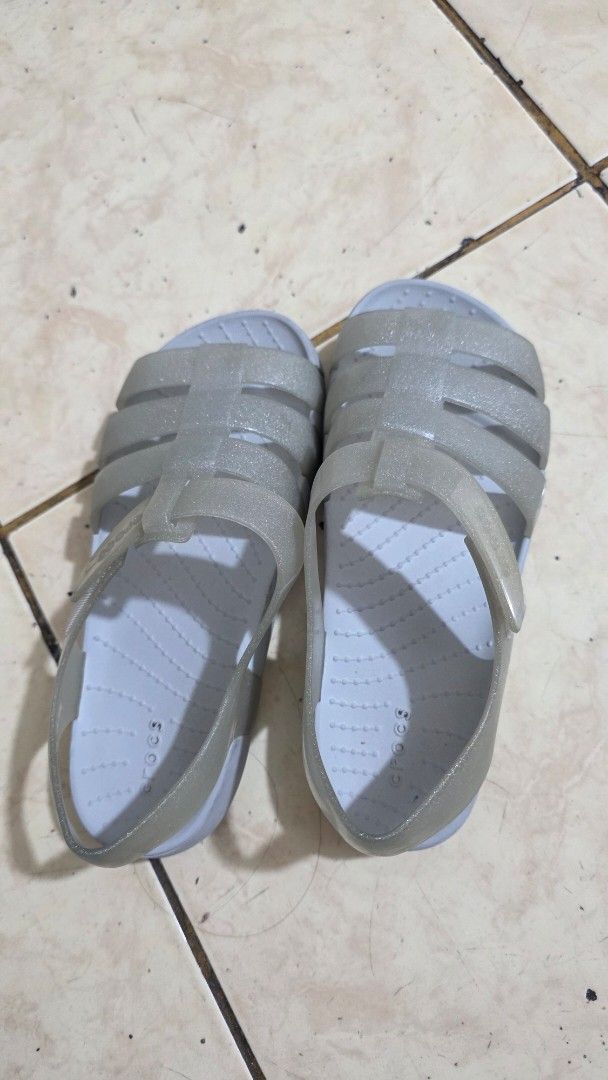 Crocs Glitter Jelly Sandals (Category: Babies & Kids Fashion) located in Manila. Submitted by joyceannelynne (Listing ID 1462825533, Image 1). Description: - Cute Crocs glitter jelly sandals - Translucent greyish color - Strappy fisherman style - Velcro strap closure for easy on/off - Ideal for beach or casual outings - Easy to clean material - Visible Crocs logo on strap.