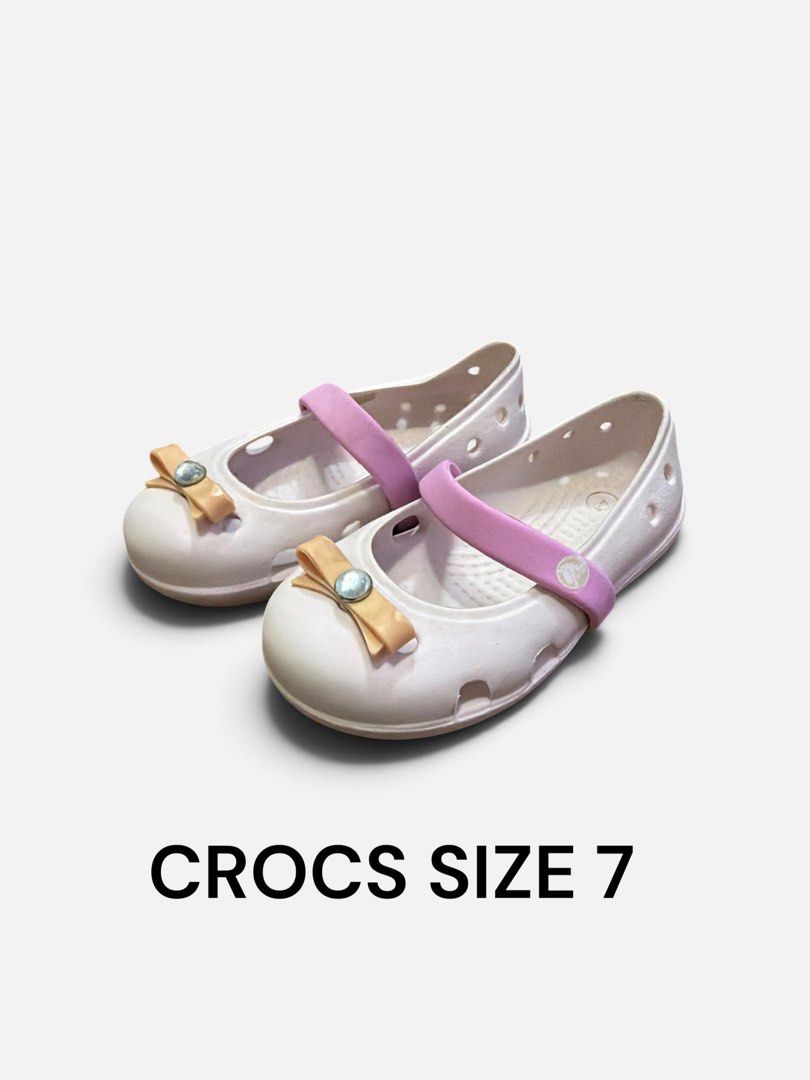 Crocs Mary Jane Flats Size 7 (Category: Babies & Kids Fashion) located in Angeles City. Submitted by momandmini9 (Listing ID 1462855241, Image 1). Description: - White Mary Jane style Crocs for kids - Features a pink strap across the top - Adorable bow with a gem on the front of each shoe - Easy slip-on design for convenience - Ideal for everyday wear.
