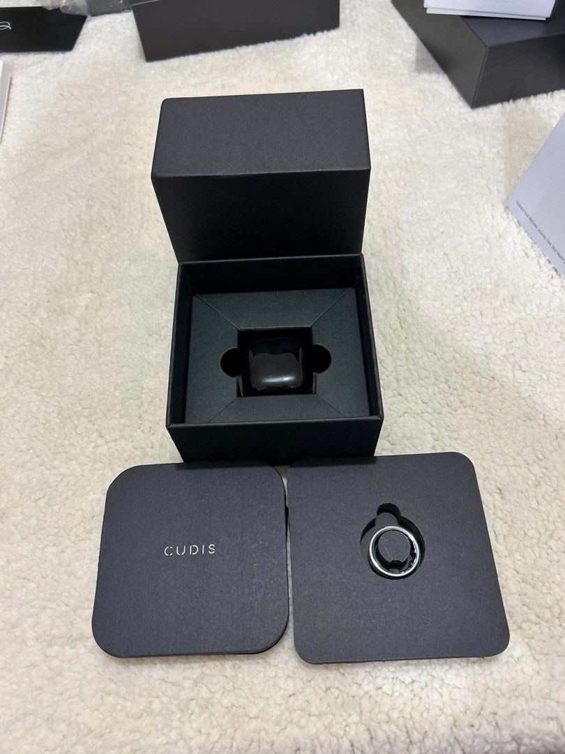 Cudis 002 smart ring (Category: Health Monitors & Weighing Scales) located in General Trias. Submitted by charlie.shop (Listing ID 1462860254, Image 2). Description: Model: CUDIS 002 Classic Finish: Titanium Silver Classic Size: 10 (Verified by factory label indicator Weight:Featherlight 3 grams (feels like a regular jewelry band) Condition:New in original box (packaging shows full serial barcodes and app download QR indicators) ⚡ Key FeaturesCom