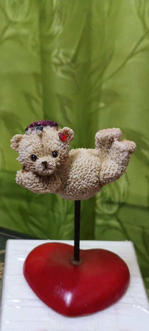 Cute Teddy Bear Figurine with Heart Base (Category: Figurines & Statues) located in Quezon City. Submitted by gemaicloset (Listing ID 1462684374, Image 2). Description: - Adorable teddy bear figurine - Holding a red heart on a wire - Perched on a stand with a bright red heart base - Ideal for display or as a thoughtful gift - Adds a sweet, charming touch to any space - Approximately [insert height here] tall.