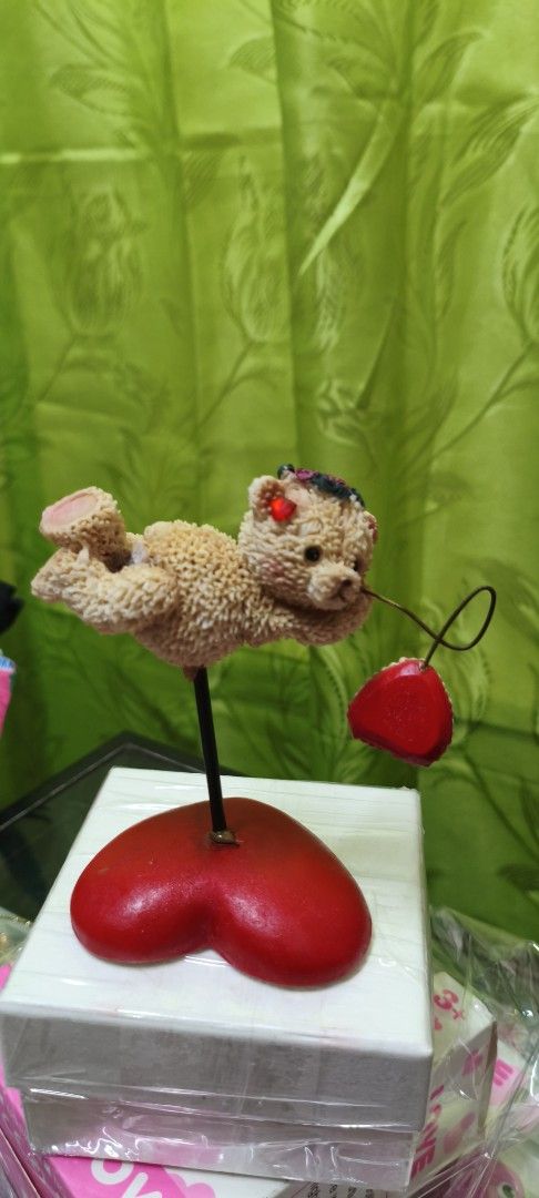 Cute Teddy Bear Figurine with Heart Base (Category: Figurines & Statues) located in Quezon City. Submitted by gemaicloset (Listing ID 1462684374, Image 1). Description: - Adorable teddy bear figurine - Holding a red heart on a wire - Perched on a stand with a bright red heart base - Ideal for display or as a thoughtful gift - Adds a sweet, charming touch to any space - Approximately [insert height here] tall.
